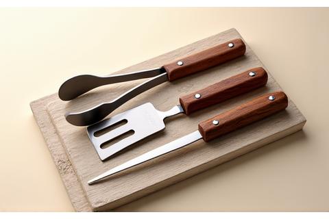 Starter BBQ Toolkit with tongs, spatula, and fork on a wooden board